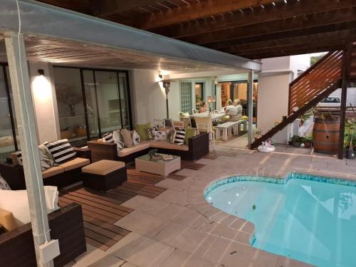 a patio with a pool and a table and chairs at Hermanus Cliff Path Lodge - No Load-shedding in Hermanus
