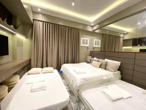 a hotel room with two beds and a mirror at Studio 205 Aibnb Mactan Cebu in Lapu Lapu City