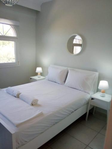 a bedroom with a large white bed with a mirror at OLIVE&VIEW in Nea Moudania