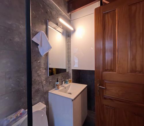 a bathroom with a sink and a toilet and a mirror at Κυκλαδίτικη Μεζονέτα in Kithnos