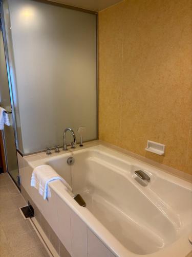 a bath tub with a faucet in a bathroom at The Yokohama Bay Hotel Tokyu in Yokohama