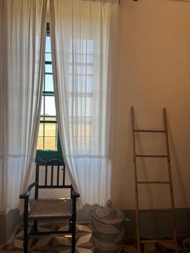 a room with two chairs and a window with curtains at Agriturismo Tenuta Muzio in Sannicola