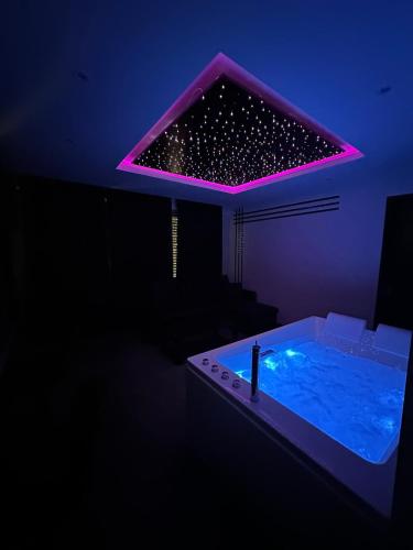 a room with a hot tub with a purple lighting at Elegance SPA Strasbourg in Strasbourg