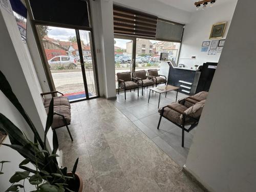 a waiting room with chairs and a table and windows at FAMİLY PLAs HOME in Edirne
