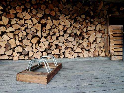 a wooden box sitting in front of a pile of wood at Apartament Loft na Kaszubach - Laskowa Góra Bieszkowice in Bieszkowice