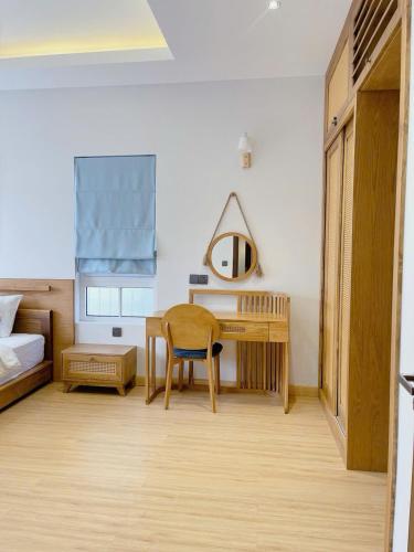 a bedroom with a table and a bed and a desk at Holiday Villa Novaworld Phan Thiet in Phan Thiet
