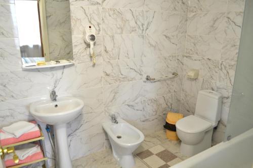 a white bathroom with a sink and a toilet at Gostinitsa Tselinnaya in Kostanay