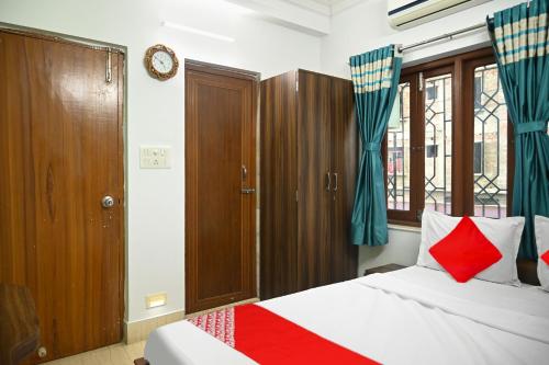a bedroom with a bed with red and blue accents at Hotel O Shraddha Residency 2 in Pānchuria