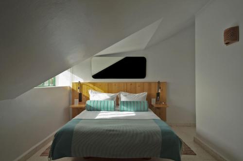 a bedroom with a bed with a tv on the wall at Al Fundok Boutique Hotel in Maasser El Chouf