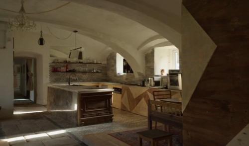 a large kitchen with an archway in a building at Villa Organica in Vroutek