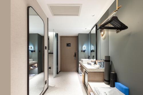 a bathroom with two sinks and a large mirror at Atour S Hotel Tianshan Road in Shanghai