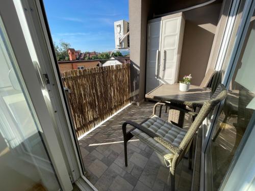 - Balcón pequeño con mesa y silla en La Familia Apartmani, en Vrnjačka Banja