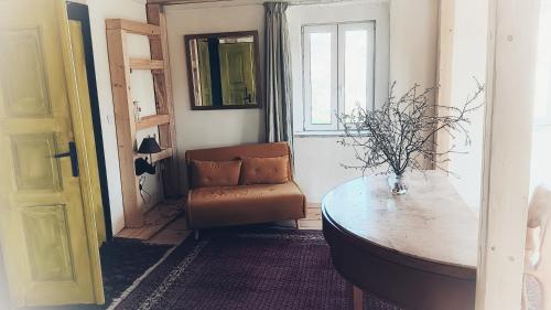 a living room with a chair and a table at Villa Organica in Vroutek
