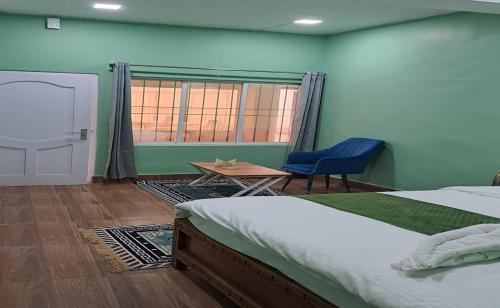 a bedroom with a bed and a table and a chair at Mudita hotel in Dirang Dzong