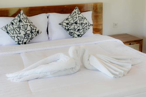 a bed with white blankets and pillows on it at The Sekumpul Villa in Sudaji