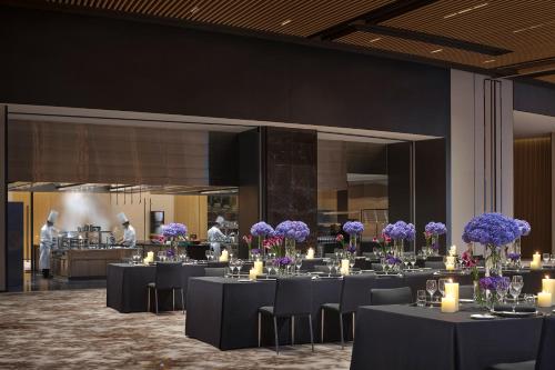 a dining room with tables with purple flowers on them at Hyatt Regency Hengqin-Free shuttle bus to Chimelong Ocean Kingdom & Hengqin Port in Zhuhai