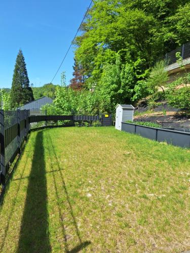 a yard with a fence and a grass field at Ferienwohnung Maison Confortable mit Sonnenterrasse und Garten, Bad Ems, Koblenz, Montabaur, Wandern, Radfahren, Mountanbiketouren in Arzbach