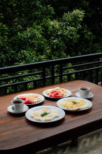 a wooden table with plates of food on it at The Sekumpul Villa in Sudaji