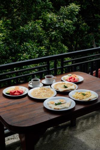 a wooden table with plates of food on it at The Sekumpul Villa in Sudaji