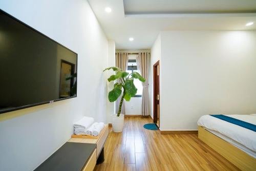 a bedroom with a bed and a flat screen tv at Ngo - The Gallery Hotel Dalat in Da Thanh