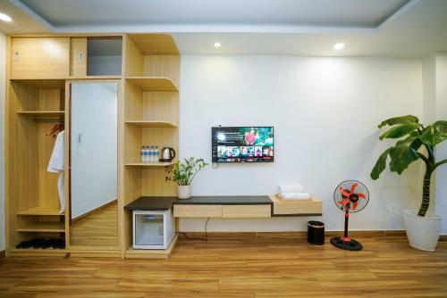 an office with a desk and a tv on a wall at Ngo - The Gallery Hotel Dalat in Da Thanh