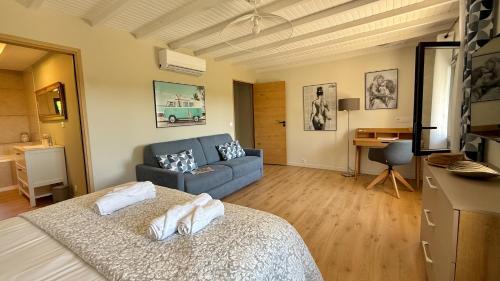 a living room with a bed and a couch at Gîtes Amour de Provence in Châteaurenard