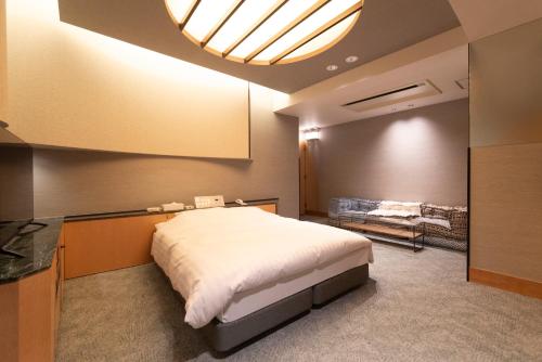a bedroom with a large white bed in a room at ホテルネオワカバ in Tsuchiura