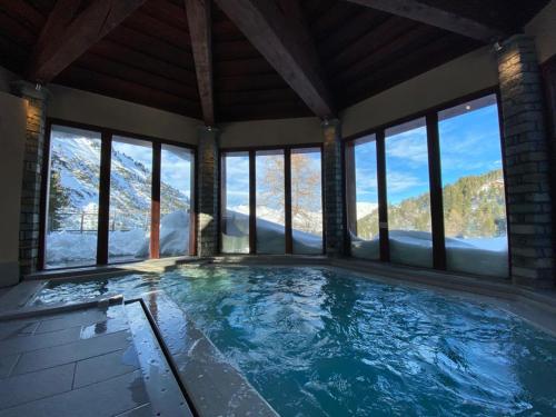 a swimming pool with a view of the mountains at 812 Manoir Savoie in Bourg-Saint-Maurice