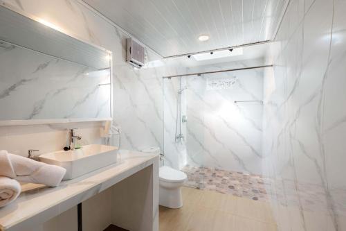 a white bathroom with a sink and a shower at The Sekumpul Villa in Sudaji
