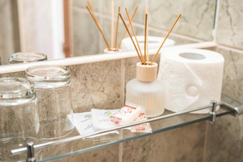 a glass shelf with toilet paper and a mirror at Hotel Gorna Banya in Sofia