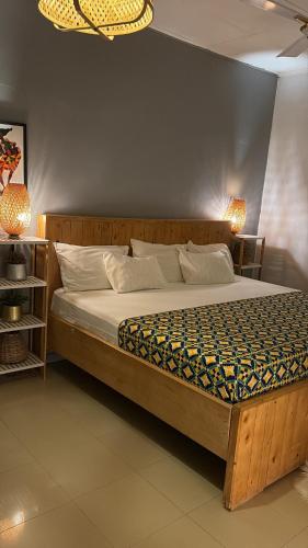 a large bed in a room with two lamps at African Treasure Beach Resort in Kokrobite