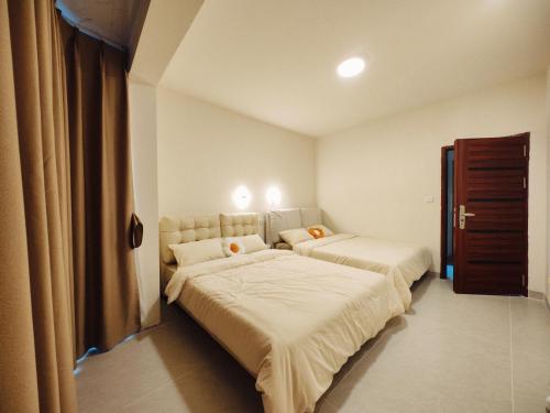 2 camas en una habitación pequeña con ermottermottermott en Yangshuo Chechen, en Yangshuo