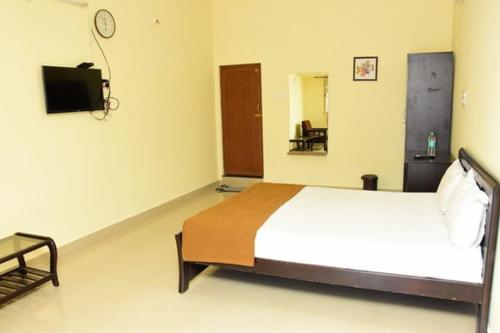 a bedroom with a bed and a tv in it at RDS Guest House Bypass in Āmbūr
