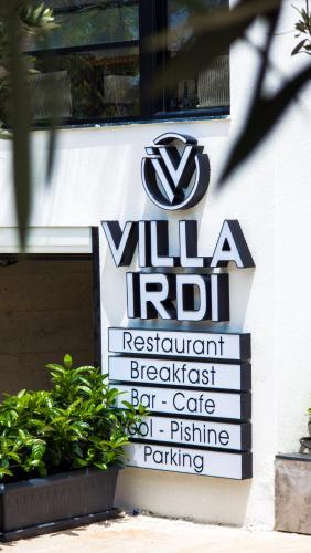 a sign for a villa rot restaurant breakfast bar and coffee parking at Vila Irdi in Ksamil