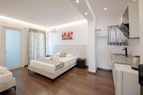 a white bedroom with a bed and a kitchen at Vila Irdi in Ksamil