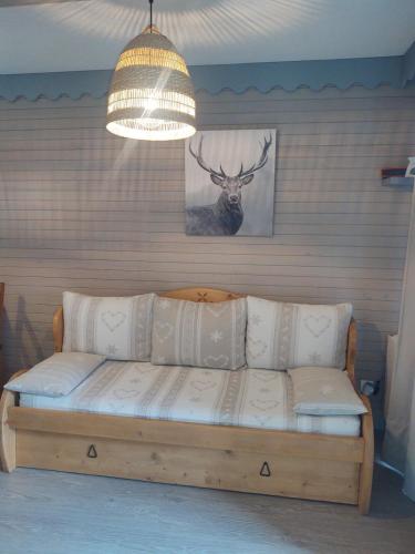 un canapé dans une pièce avec une photo d'un cerf dans l'établissement Appartement au pied de la montagne, à Allos