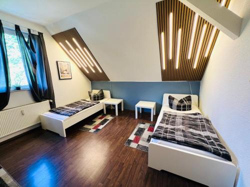 ein Zimmer mit zwei Betten und einem Tisch in der Unterkunft Comfort & Relax mit Sky & PlayStation - Haus Burgstadt in Altena