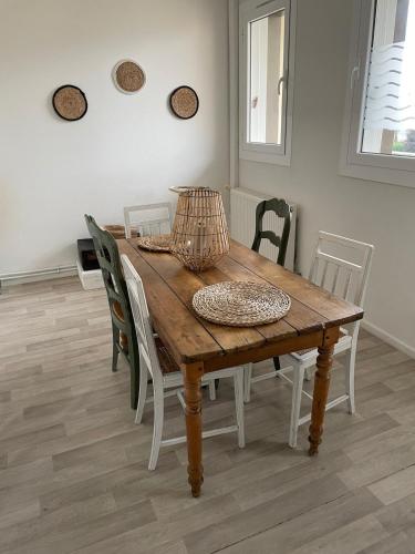 une table en bois avec des chaises et un panier sur le dessus dans l'établissement Spacious apartment in Guingamp, à Guingamp
