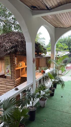 an outdoor patio with palm trees and a building at African Treasure Kokrobite in Kokrobite