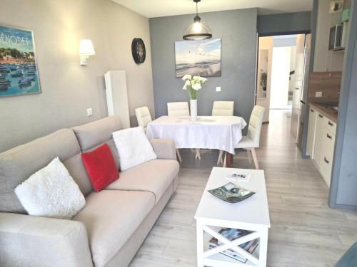 a living room with a couch and a table at Les Mouettes Marines - Charmant appt vue mer in Bénodet