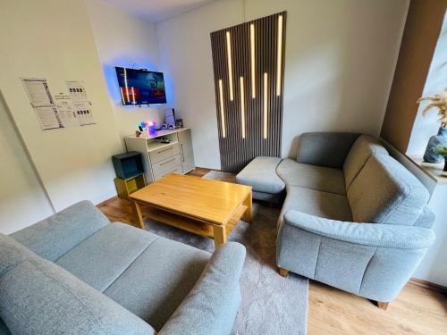 ein Wohnzimmer mit zwei Sofas und einem Tisch in der Unterkunft Comfort & Relax mit Sky & PlayStation - Haus Burgstadt in Altena