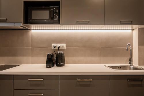 a kitchen with a sink and a microwave at WYZ Museum by UPSTREET in Athens