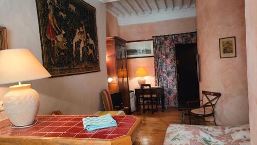 a room with a table with a lamp on it at Trésor in Uzès