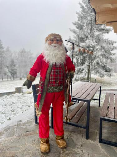 a santa claus is standing next to a bench at Wioska Jasia i Małgosi in Izdebnik