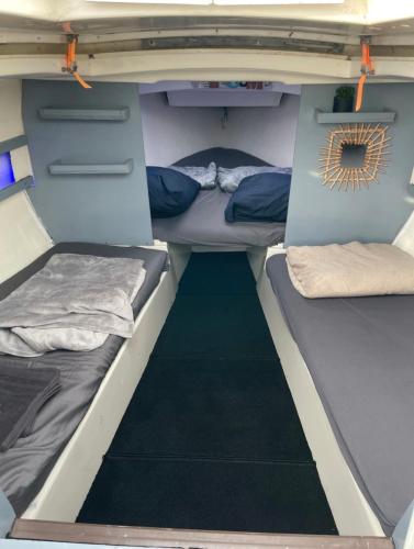 Deux lits à l'arrière d'un camping-car dans l'établissement Voilier Port Deauville avec parking privé gratuit, à Deauville