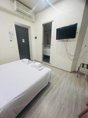 a bedroom with a white bed and a flat screen tv at Hotel Giardinetto Al Sant'Orsola in Bologna