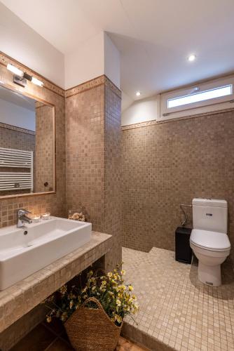 a bathroom with a tub and a toilet and a sink at Villa Maria Syros in Posidhonía