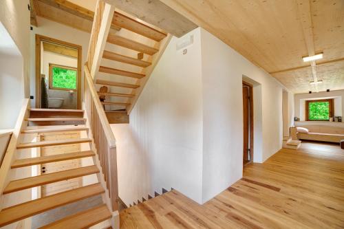 a staircase in a home with white walls and wooden floors at Schlossbauer große Ferienwohnung in San Leonardo in Passiria