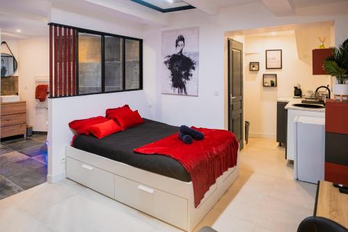 Un dormitorio con una cama grande con almohadas rojas. en Studio Cosy avec jacuzzi privé, en Béziers