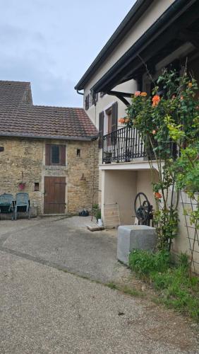 a house with a courtyard with a balcony and a building at La rainette in Chaux